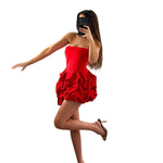 A vibrant red strapless, sleeveless mini dress with a unique one-shoulder collar and a large flower-shaped hem, made of polyester.
