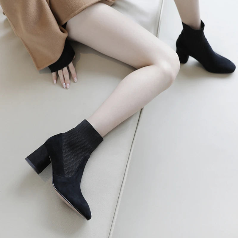 A pair of black casual lightweight ankle heel boots with a thick heel, against a neutral background