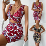 A close-up shot of a person wearing a wine red, floral-printed, short-skirt dress. The dress has thin shoulder straps that cross over a high-waisted, fitted back.