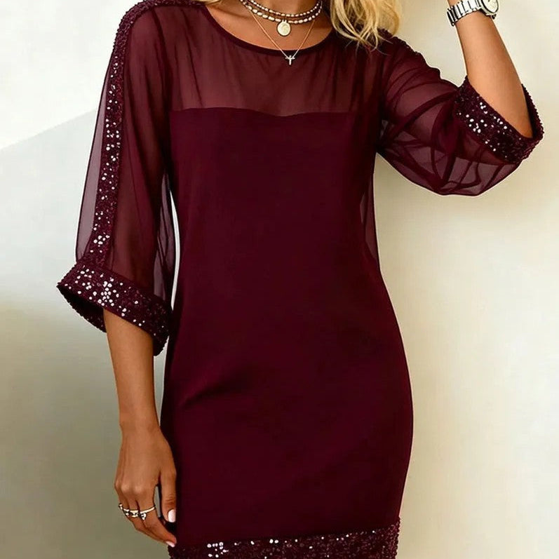 Burgundy dress with sheer sleeves and hem on a plain background