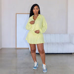 A model wearing a solid color two-piece outfit consisting of a short skirt, long pants, and a hoodie top.