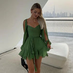 Green off-shoulder mini dress with long princess sleeves, POLO neck, high waist, lace-up detail, pleats, and an irregular hem in a solid color polyester material.