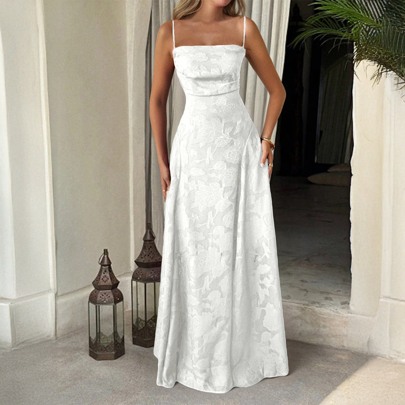 Woman wearing a white lace dress standing in a doorway with lanterns and a plant in the background.