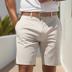 Person wearing beige shorts and a white shirt with a blurred background