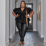 Woman in a black outfit standing in a hallway