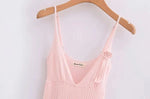A sleeveless, V-neck, A-line mini dress in a criss-cross knitted pattern, adorned with floral appliques, available in pink and white, with a backless design.