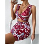A close-up shot of a person wearing a wine red, floral-printed, short-skirt dress. The dress has thin shoulder straps that cross over a high-waisted, fitted back.