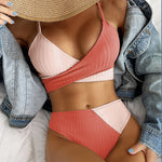 Person wearing a two-tone pink and red bikini with denim jacket and pants.