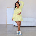 A model wearing a solid color two-piece outfit consisting of a short skirt, long pants, and a hoodie top.