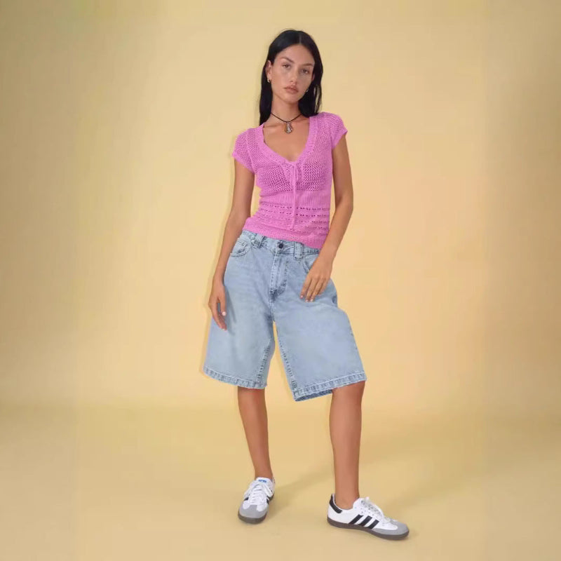 A pair of dark blue, mid-length, vintage-style denim shorts with a distressed finish. The shorts are laid flat, showcasing the straight-leg cut and medium-rise waist.