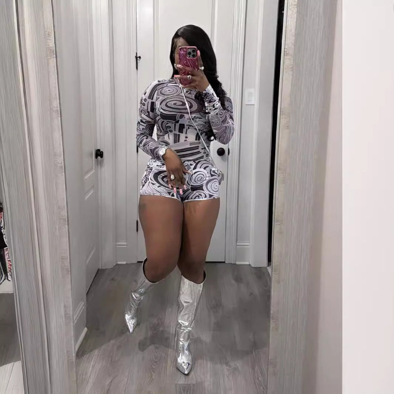 Person wearing a patterned outfit and silver knee-high boots in a room.