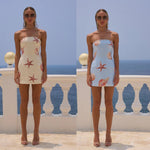 A sleeveless, apricot-colored, sequin-printed mini dress with a chest wrap design, modeled on a person.