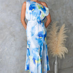 Model wearing a light blue split sleeveless printed midi dress with elegant flair in outdoor setting