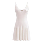 A sleeveless, V-neck, A-line mini dress in a criss-cross knitted pattern, adorned with floral appliques, available in pink and white, with a backless design.
