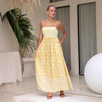 A sleeveless, high-waisted, midi-length dress with a printed pattern and a one-shoulder, backless design, photographed on a white background.