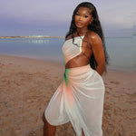 A woman wearing a white, sheer mesh midi dress with a high slit and a stylish oblique neckline. The dress is sleeveless and fitted.
