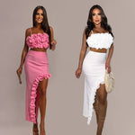 A model wearing a pink sleeveless top and a matching long skirt with a ruffle hem, part of a two-piece set.