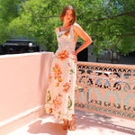 A model wearing a floral patterned, long, backless, and strapless midi dress, suitable for office wear.