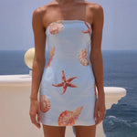 A sleeveless, apricot-colored, sequin-printed mini dress with a chest wrap design, modeled on a person.