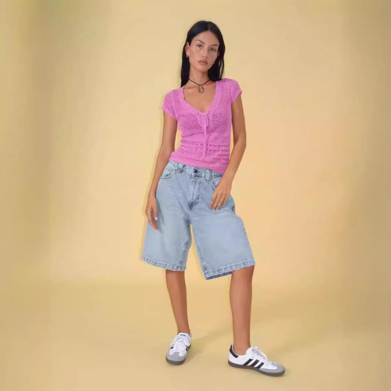 A pair of dark blue, mid-length, vintage-style denim shorts with a distressed finish. The shorts are laid flat, showcasing the straight-leg cut and medium-rise waist.
