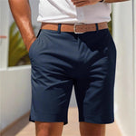 Person wearing navy shorts with a brown belt in an outdoor setting