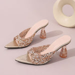 Pair of glittery high-heeled shoes on a light pink background