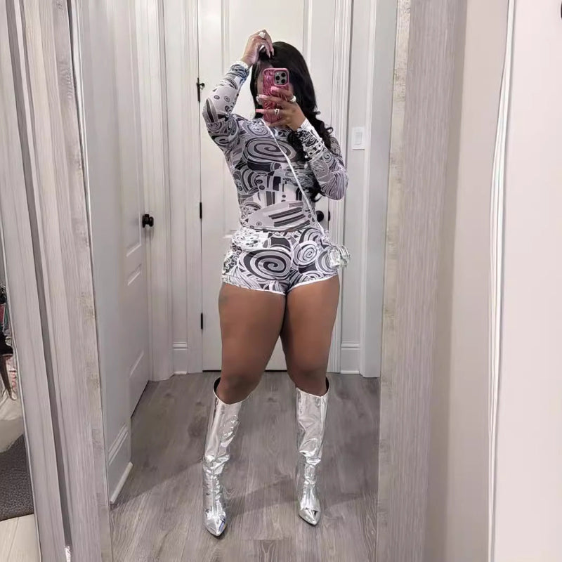 Person wearing a patterned outfit with silver high boots in a mirror selfie.