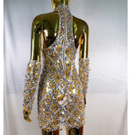 Gold and silver embellished dress on a mannequin against a white background