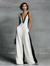 Model wearing a white V-neck wide-leg jumpsuit with black contrast trim.