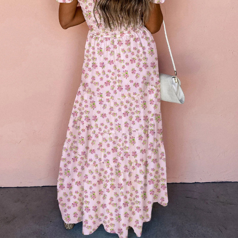 Woman wearing a floral dress against a pink wall