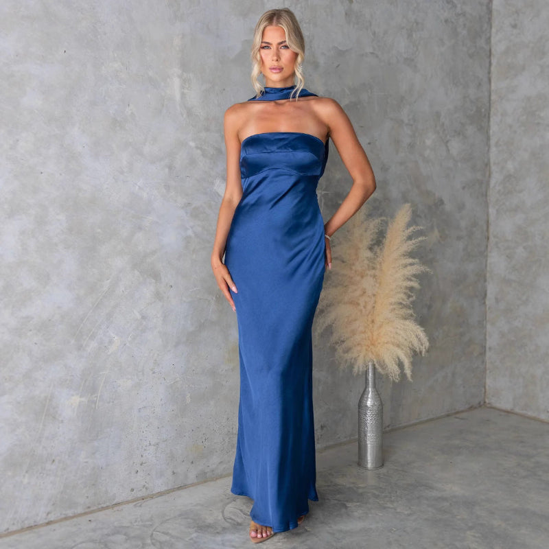 Model wears sleeveless blue hanging neck midi dress with elegant flow and high-fashion appeal