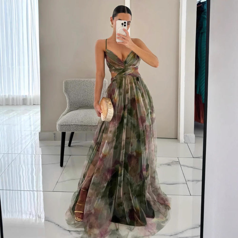 Woman wearing a strapless maxi dress with vibrant abstract print, holding gold clutch