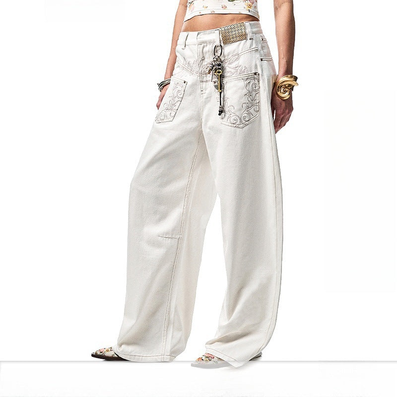 A pair of white, retro-style curved knife jeans with reverse embroidered detailing. The unique seam and leg shape are visible, highlighting the modern and edgy design.