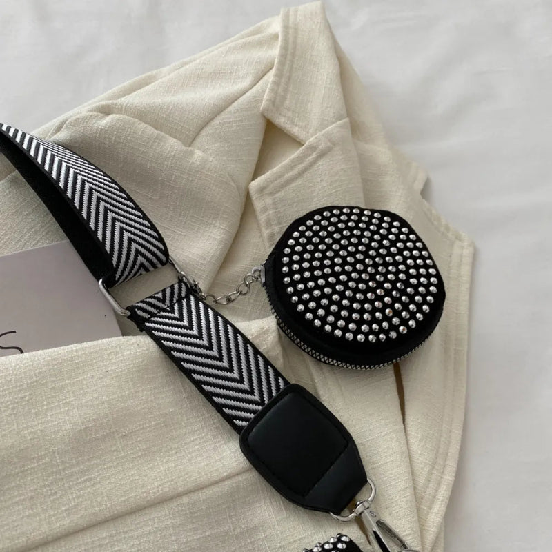 A medium-sized black crossbody bag made of PU material, adorned with metallic studs and featuring an adjustable strap.