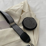 A medium-sized black crossbody bag made of PU material, adorned with metallic studs and featuring an adjustable strap.