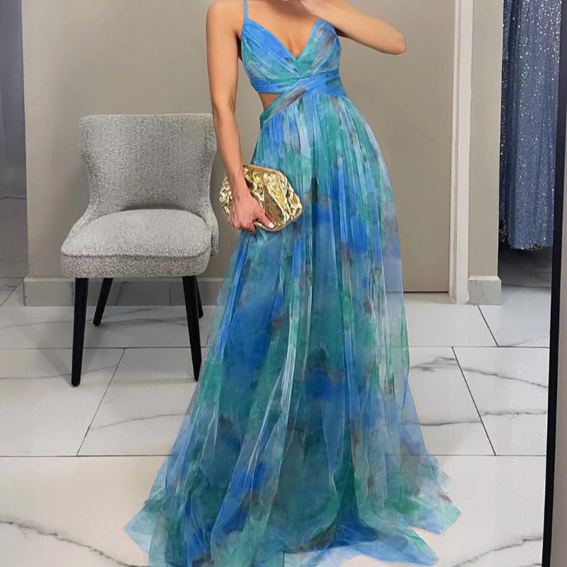 Woman wearing a strapless maxi dress with vibrant abstract print, holding gold clutch