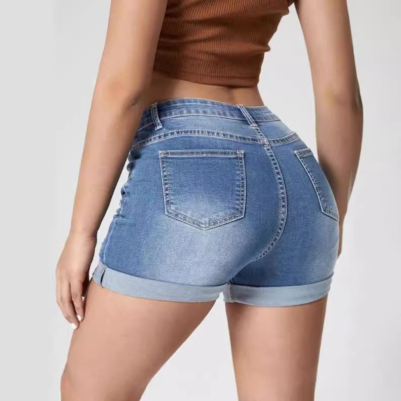 A pair of light blue, high-waisted denim shorts with distressed holes and a cuffed hem. The shorts have a skinny fit and are displayed on a flat surface.