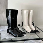 A pair of elegant women's knee-high boots with a pointed toe and thin heel, shown in both black and apricot colors.