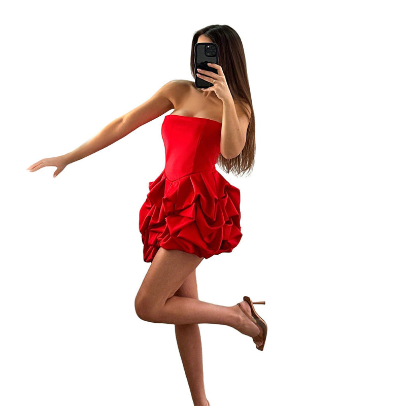 A vibrant red strapless, sleeveless mini dress with a unique one-shoulder collar and a large flower-shaped hem, made of polyester.