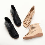 A pair of black high-top Roman sandals with a fish mouth toe style and lace-up closure.