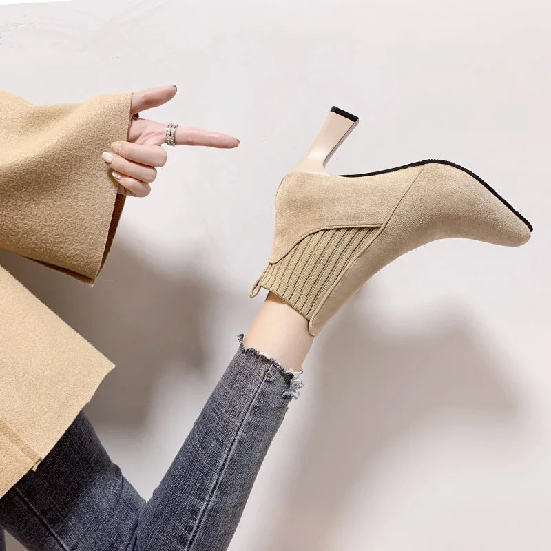 A pair of black high heel platform Martin boots with a pointed toe and thick heel.