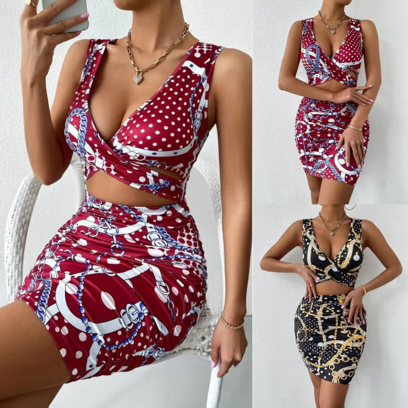 A close-up shot of a person wearing a wine red, floral-printed, short-skirt dress. The dress has thin shoulder straps that cross over a high-waisted, fitted back.