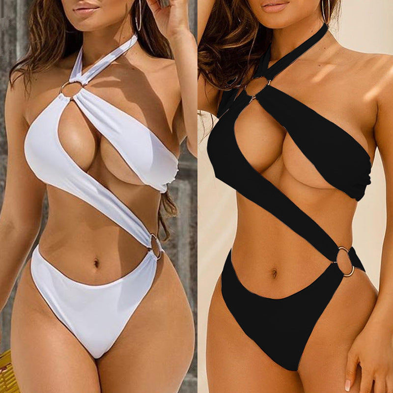 Two women wearing white and black bikini sets against a neutral background.