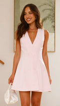A model wearing a solid color sleeveless short V-neck dress.
