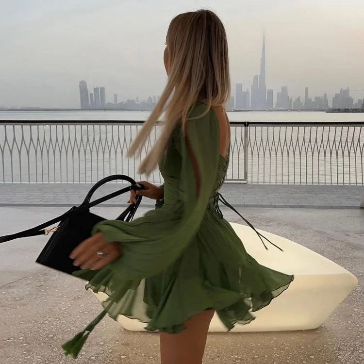 Green off-shoulder mini dress with long princess sleeves, POLO neck, high waist, lace-up detail, pleats, and an irregular hem in a solid color polyester material.