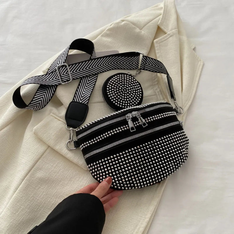 A medium-sized black crossbody bag made of PU material, adorned with metallic studs and featuring an adjustable strap.