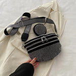 A medium-sized black crossbody bag made of PU material, adorned with metallic studs and featuring an adjustable strap.