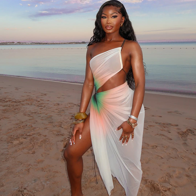 A woman wearing a white, sheer mesh midi dress with a high slit and a stylish oblique neckline. The dress is sleeveless and fitted.