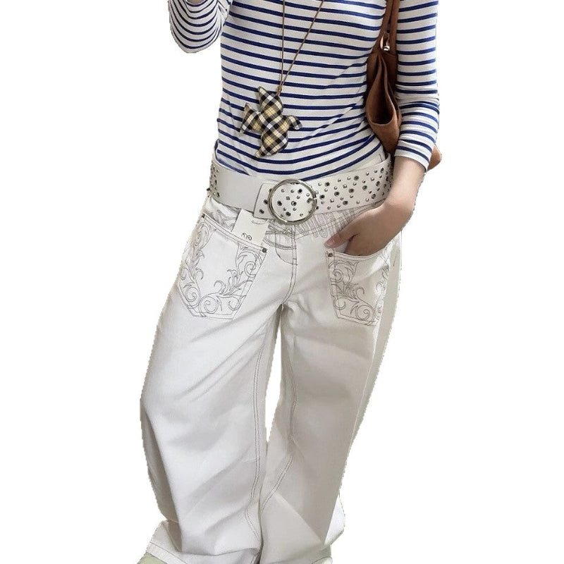 A pair of white, retro-style curved knife jeans with reverse embroidered detailing. The unique seam and leg shape are visible, highlighting the modern and edgy design.
