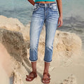 Woman wearing sky blue denim capri jeans with a flattering mid-rise fit and pocket details, standing confidently outdoors.